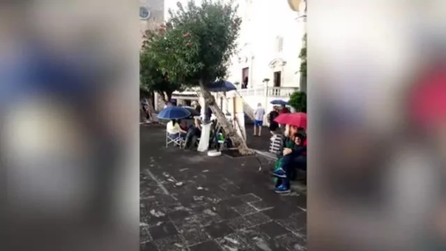 Taormina, cittadini con l'ombrello per la pioggia di lapilli dell'Etna