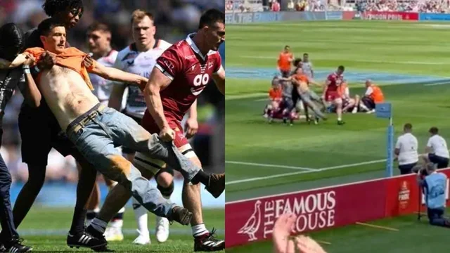 Gli attivisti entrano in campo e vengono portati fuori con l'aiuto del rugbista